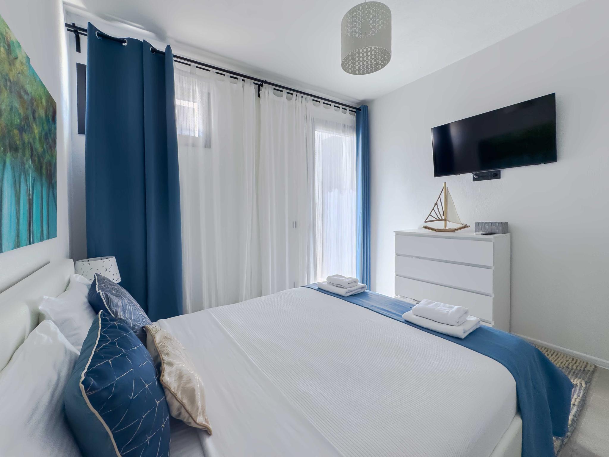 Sunlit bedroom at Damari villa in Skiathos with warm Mediterranean light through the window — best enjoyed in the long summer days of June through September