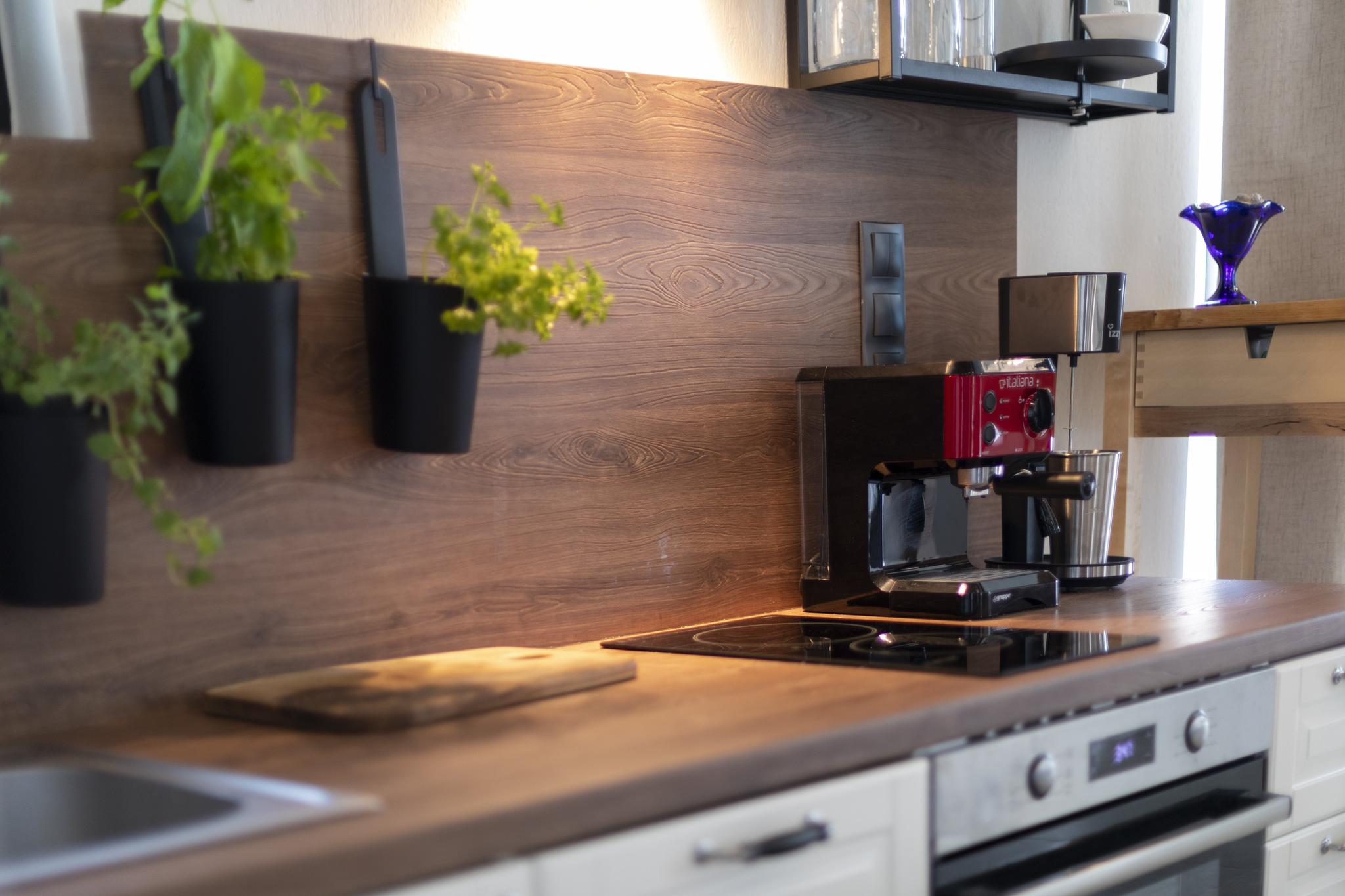 A minimalist, high-end Mediterranean kitchen in a luxury Skiathos villa, featuring built-in appliances and garden views.
